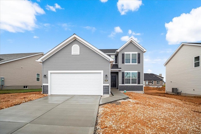 traditional home with central AC, a garage, and concrete driveway