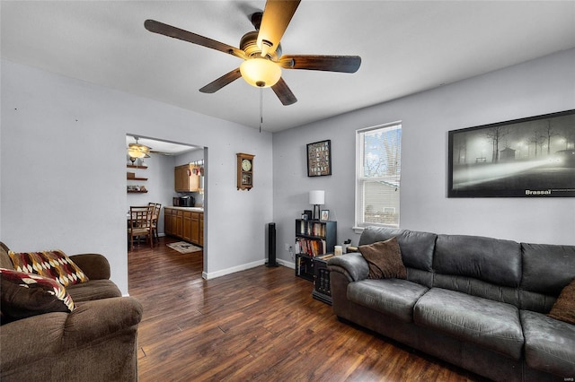 living room featuring ceiling fan and dark wood-type flooring