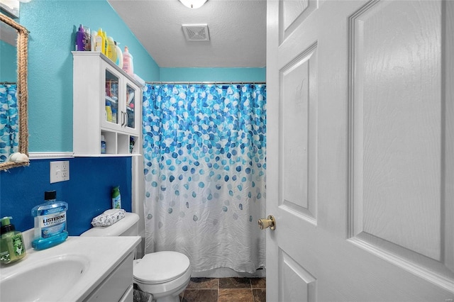 bathroom featuring toilet, vanity, a shower with shower curtain, and a textured ceiling