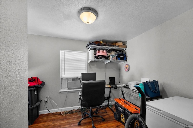 home office featuring a textured ceiling and dark hardwood / wood-style flooring