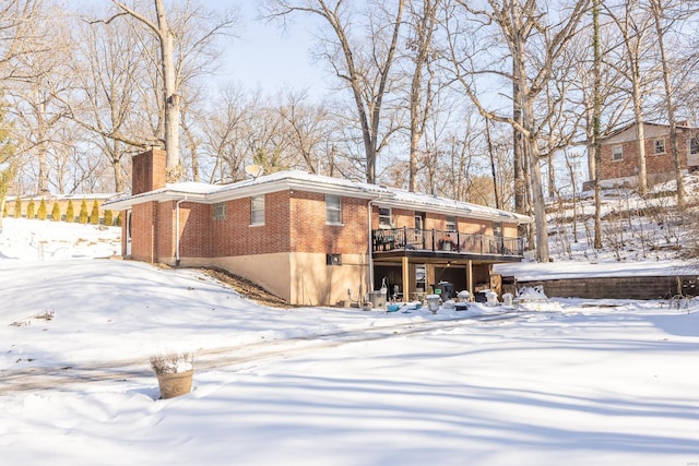 snow covered house with a deck