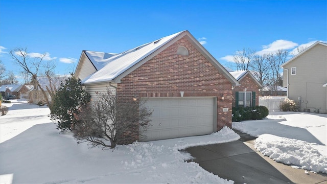 view of snowy exterior with a garage