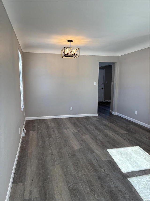 unfurnished room with dark hardwood / wood-style flooring and a chandelier