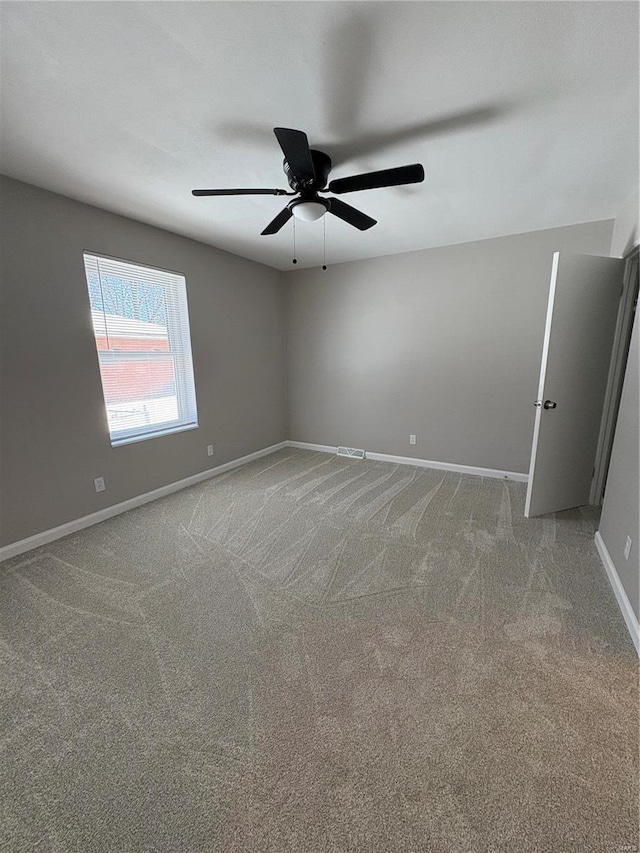 carpeted spare room featuring ceiling fan