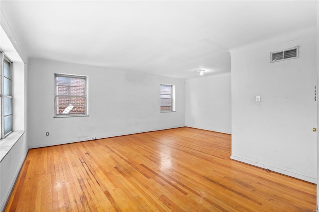 empty room featuring plenty of natural light and light hardwood / wood-style flooring