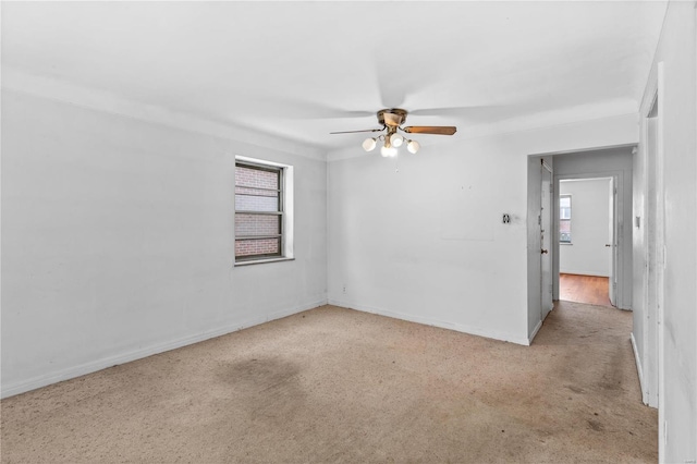 empty room featuring ceiling fan and light carpet