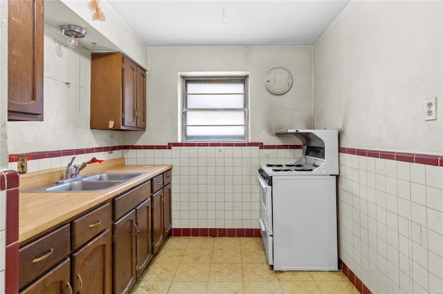 kitchen with sink, tile walls, and gas range gas stove