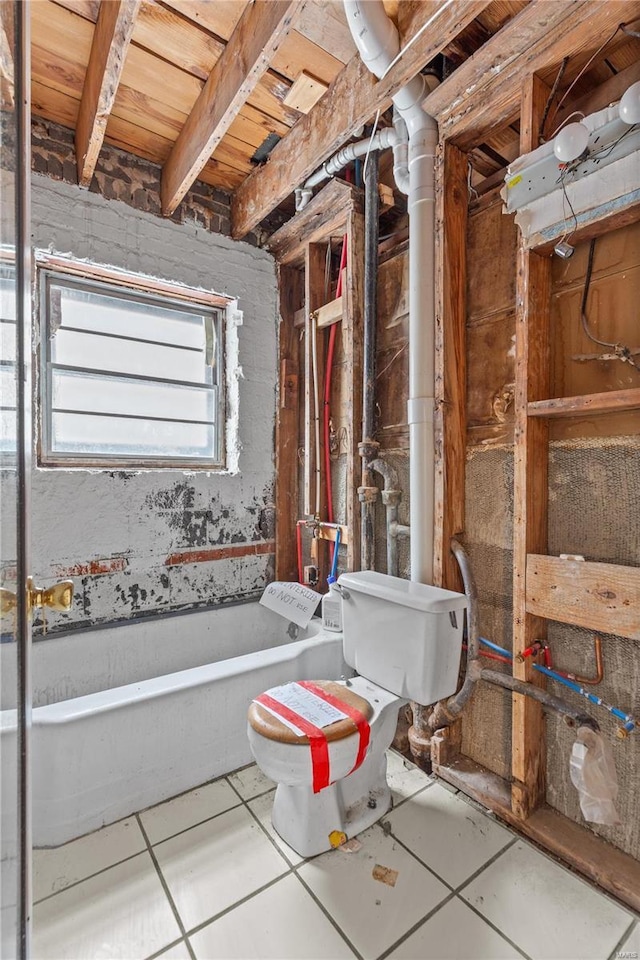 bathroom with toilet, tile patterned flooring, and a tub