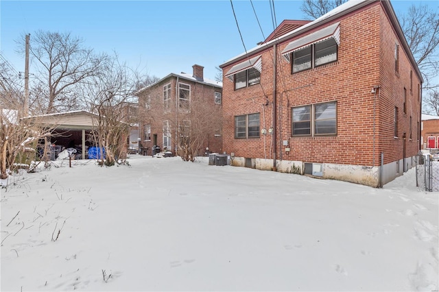 snow covered property featuring central AC unit