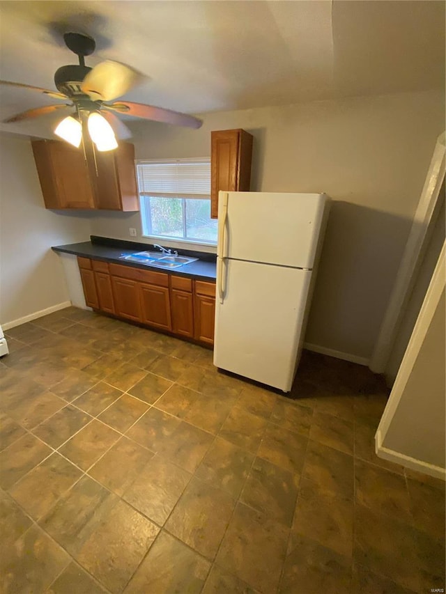 kitchen featuring ceiling fan, sink, and white refrigerator