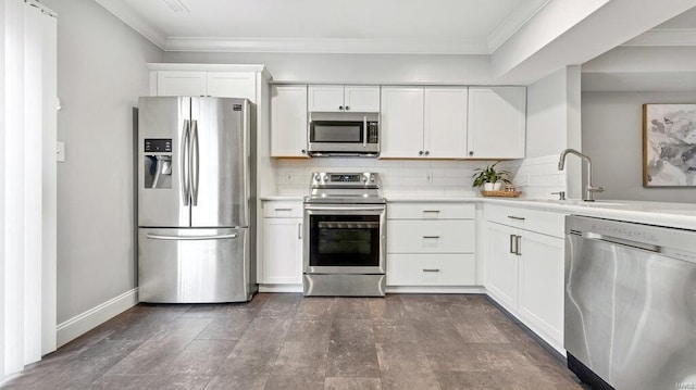 kitchen with stainless steel appliances, white cabinets, tasteful backsplash, and sink