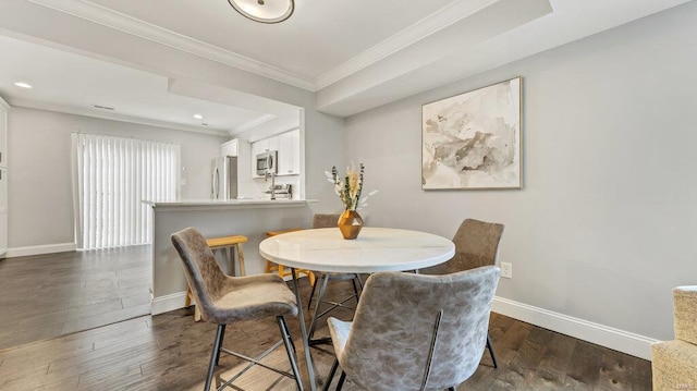 dining space featuring dark hardwood / wood-style flooring and crown molding