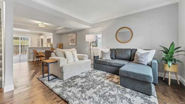 living room featuring a healthy amount of sunlight, hardwood / wood-style floors, and crown molding