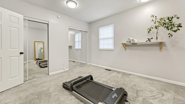 exercise area with a textured ceiling and carpet