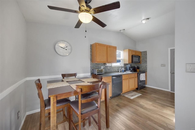 kitchen with vaulted ceiling, light wood-type flooring, tasteful backsplash, ceiling fan, and black appliances