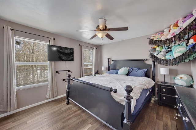 bedroom with ceiling fan, multiple windows, and hardwood / wood-style flooring