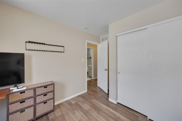 bedroom with a closet and light hardwood / wood-style flooring