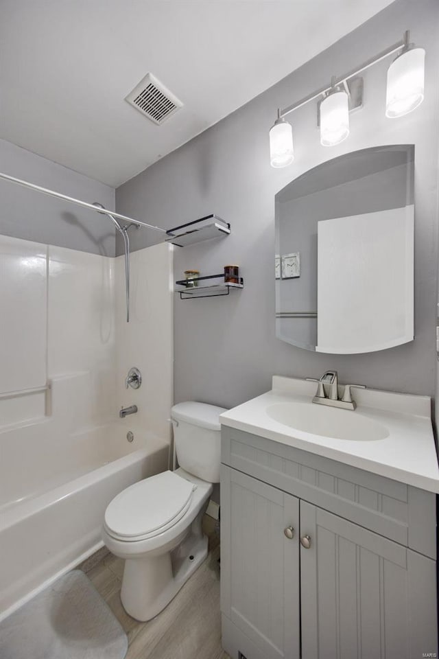 full bathroom featuring toilet, vanity, hardwood / wood-style flooring, and tub / shower combination