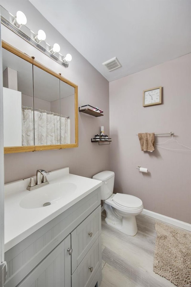 bathroom featuring toilet, hardwood / wood-style floors, and vanity