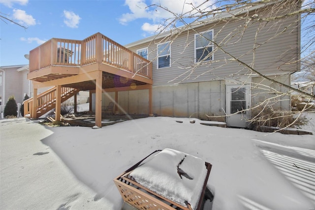 snow covered house featuring a deck