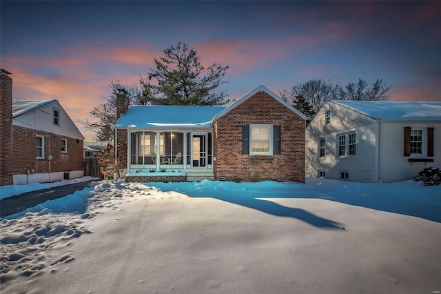 snow covered house with a sunroom