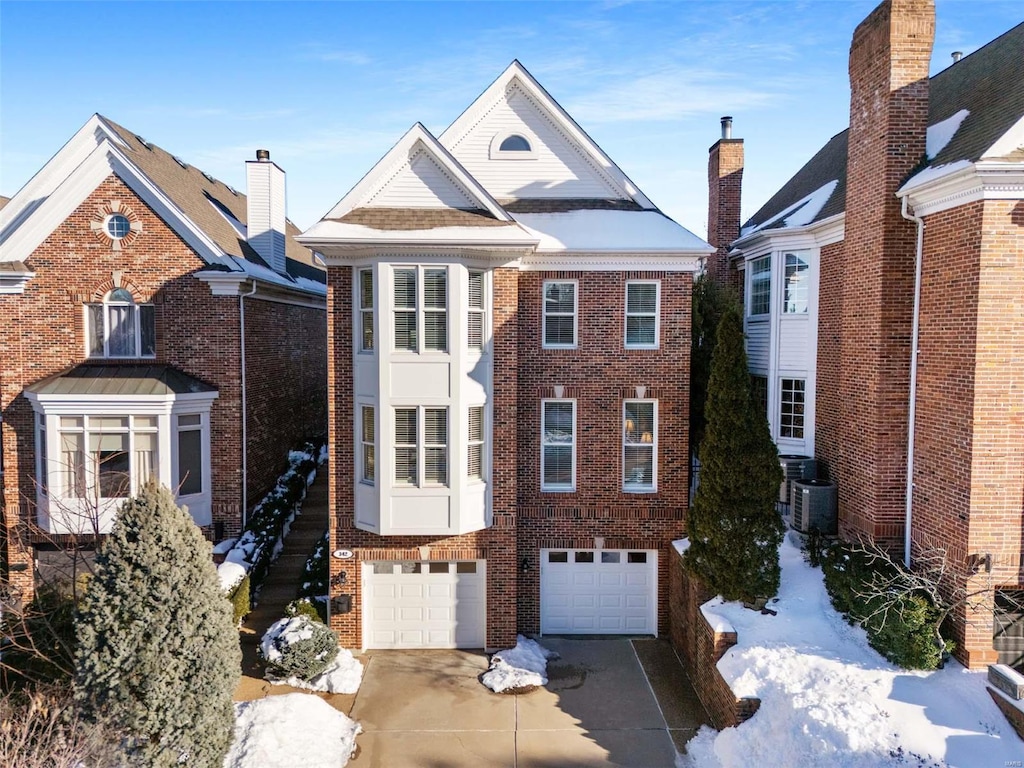 view of property featuring a garage and central AC