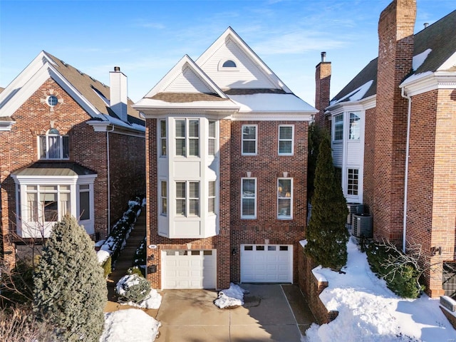 view of property featuring a garage and central AC