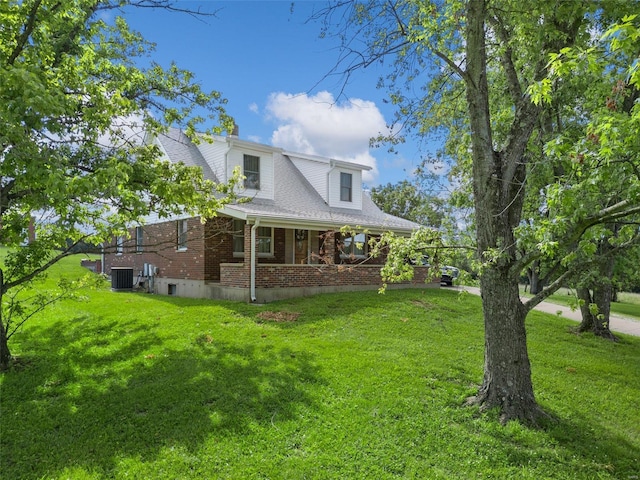 exterior space with covered porch, a lawn, and central AC