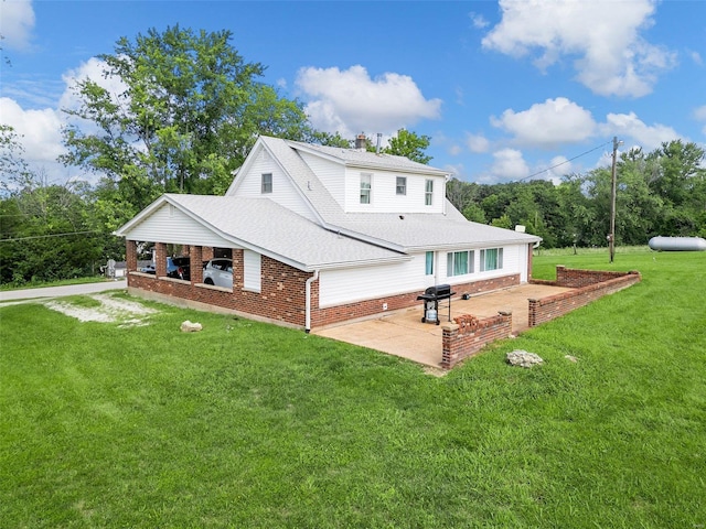 rear view of house with a patio and a yard