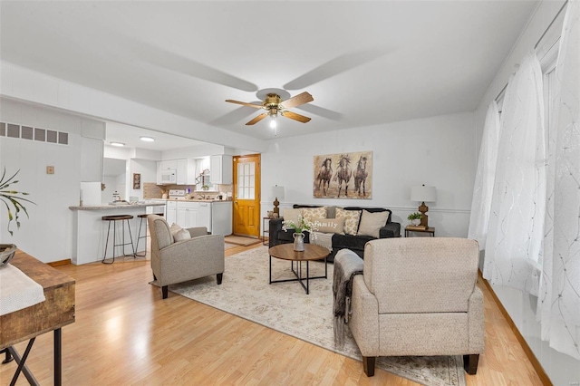 living room with ceiling fan and light wood-type flooring