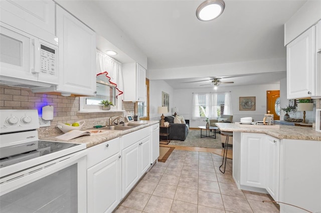 kitchen with white cabinetry, sink, backsplash, electric range oven, and light tile patterned flooring