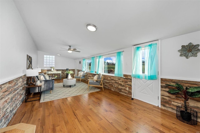 living room featuring ceiling fan, light hardwood / wood-style flooring, lofted ceiling, and a healthy amount of sunlight