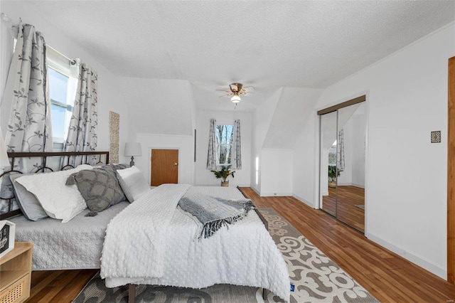 bedroom featuring wood-type flooring, a textured ceiling, a closet, and ceiling fan