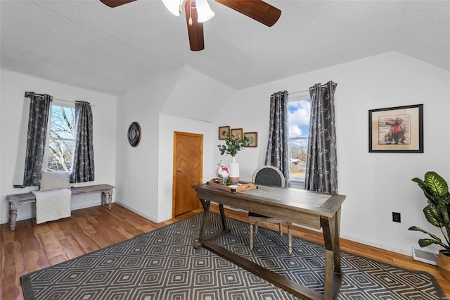 home office with a textured ceiling, lofted ceiling, and hardwood / wood-style floors