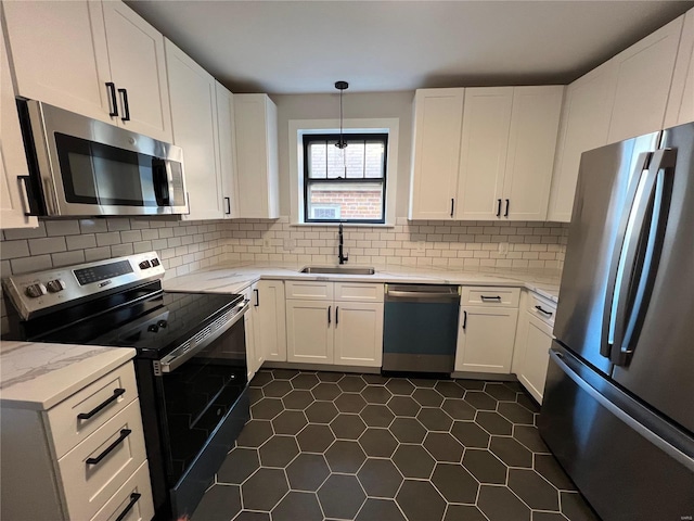 kitchen featuring appliances with stainless steel finishes, decorative light fixtures, white cabinetry, and sink