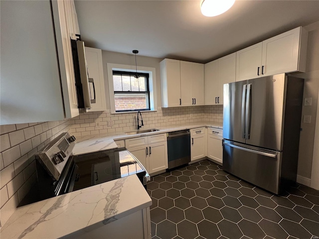 kitchen featuring appliances with stainless steel finishes, white cabinetry, pendant lighting, and sink