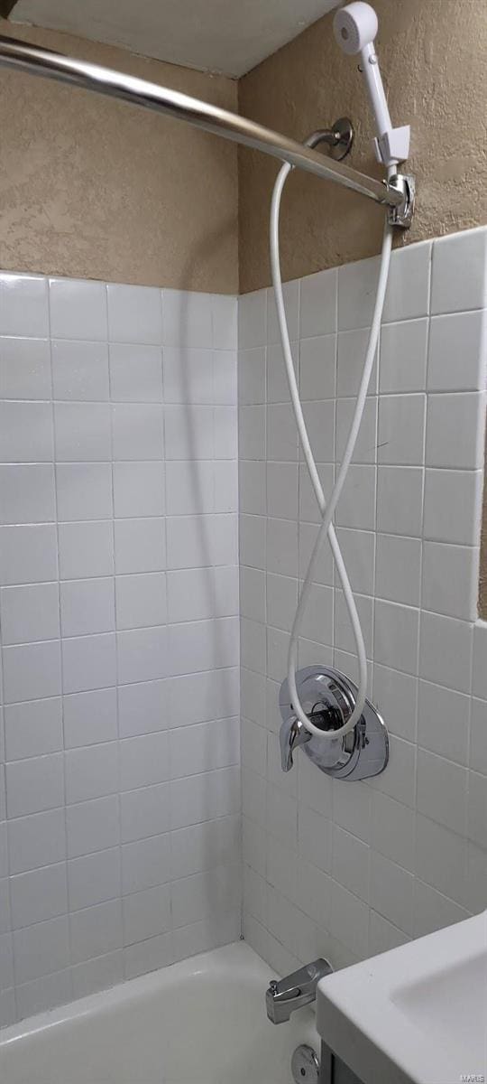 bathroom featuring tiled shower / bath