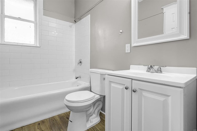 full bathroom with wood-type flooring, toilet, tiled shower / bath combo, and vanity