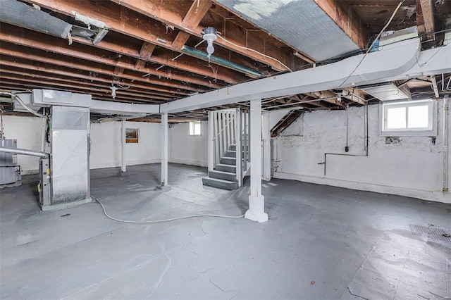 basement featuring heating unit and water heater