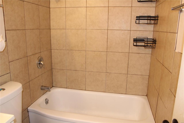 bathroom featuring toilet and tile walls