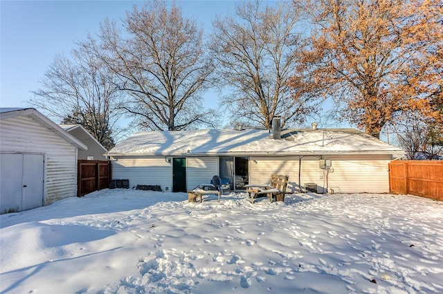 snow covered house with a fire pit