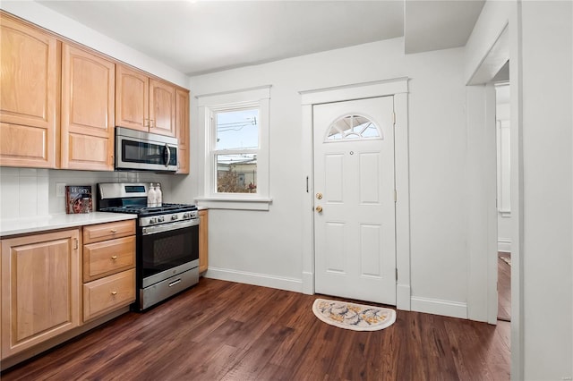 kitchen featuring light brown cabinetry, backsplash, appliances with stainless steel finishes, and dark hardwood / wood-style floors