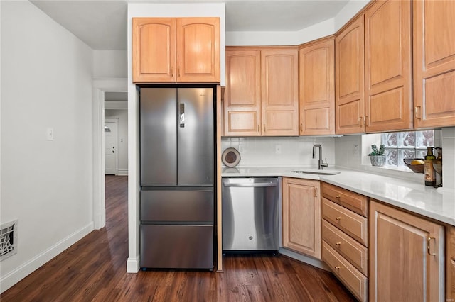 kitchen featuring stainless steel appliances, backsplash, dark hardwood / wood-style flooring, light stone countertops, and sink