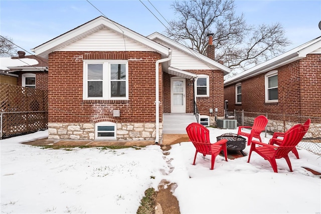 snow covered property featuring central AC and an outdoor fire pit