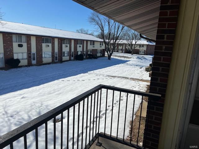 view of snow covered back of property