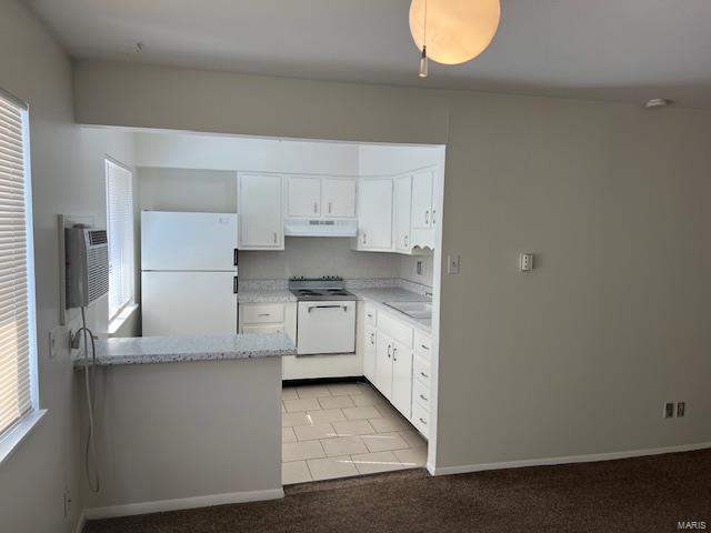 kitchen with white appliances, kitchen peninsula, white cabinets, ventilation hood, and light carpet