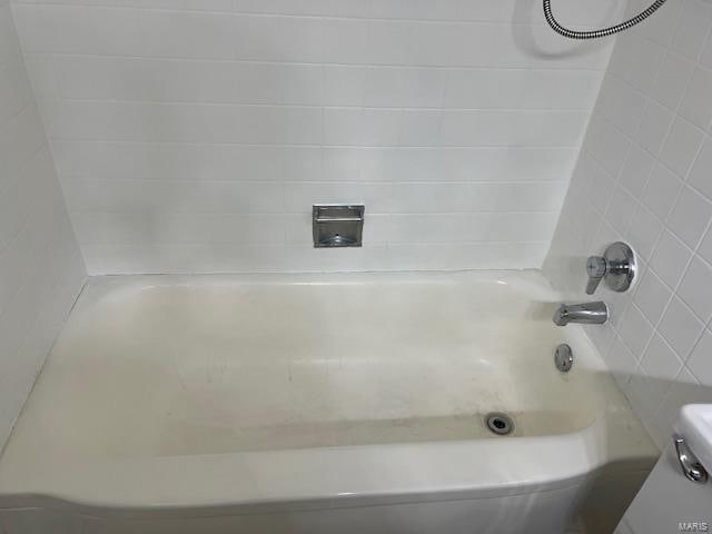 bathroom featuring toilet and tiled shower / bath combo