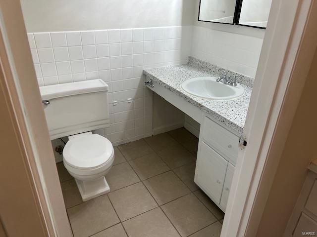 bathroom with tile walls, vanity, tile patterned floors, and toilet