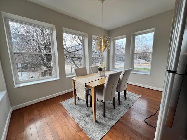 dining room with dark hardwood / wood-style flooring and an inviting chandelier