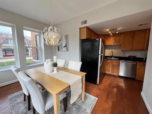 dining room featuring an inviting chandelier, dark wood-type flooring, and sink